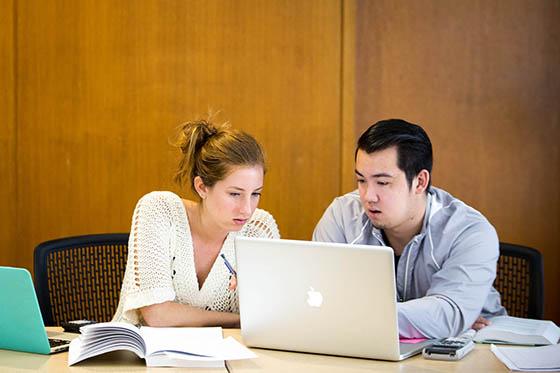Photo of two Chatham University students looking at a laptop together.